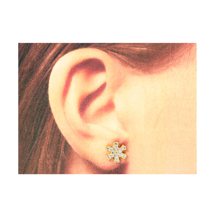 Close-up of an ear wearing a diamond stud earring with hair partially visible.