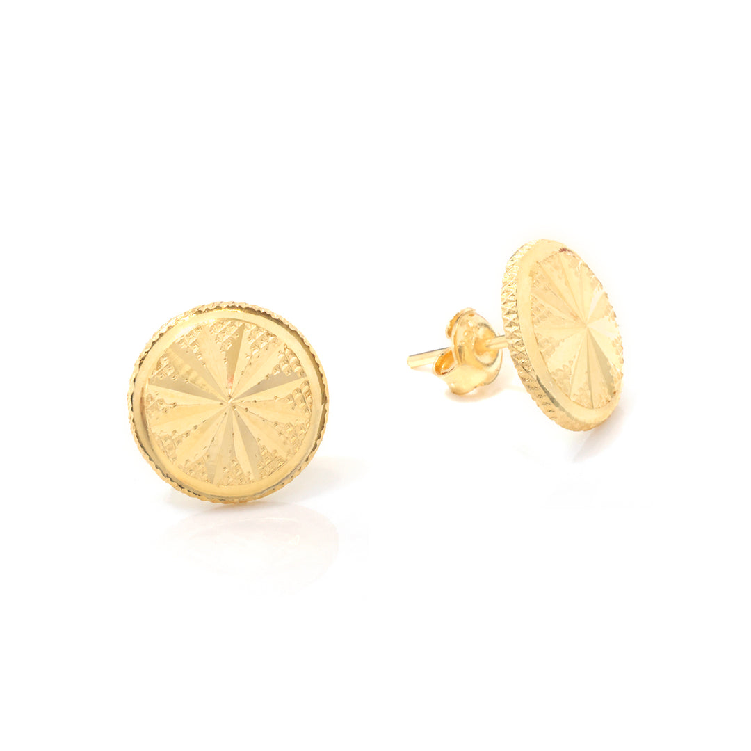 A pair of round gold stud earrings with a textured, starburst-like engraved face and a beaded outer rim, shown on a clean white background.