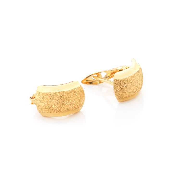 A pair of gold-toned clip-on earrings with a textured, glittery finish, displayed on a clean white background.