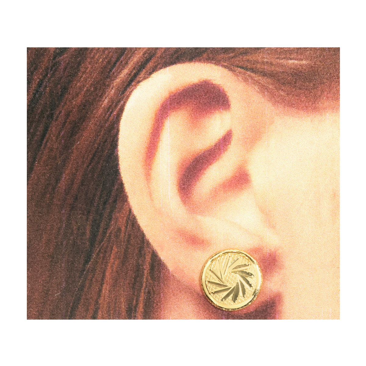 A close-up of a person's ear wearing a small round gold stud earring with a sunburst or leaf-like engraved pattern.