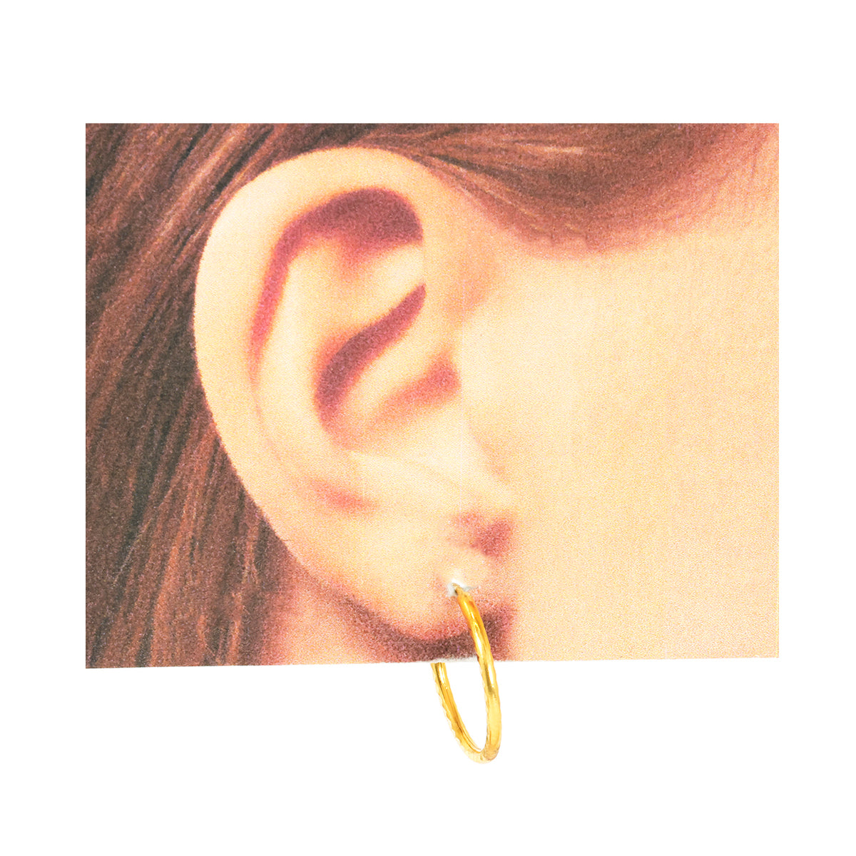 Gold hoop earring worn by a person with brown hair.