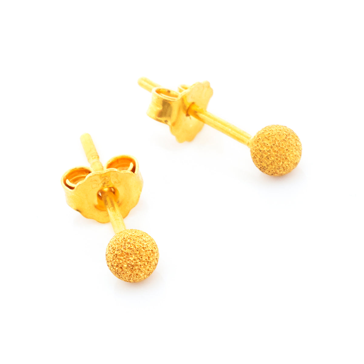 Pair of gold spherical stud earrings on a white background