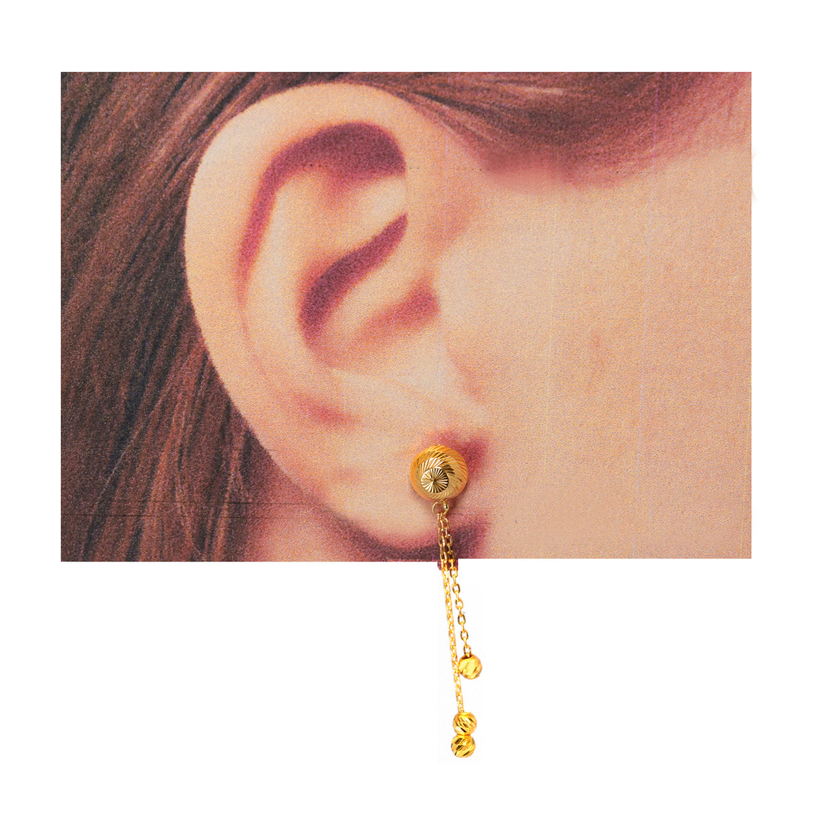 Gold earring worn on an ear with a plain background