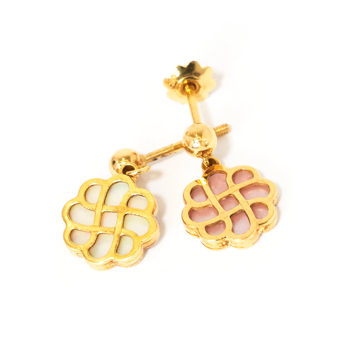 Gold earrings with floral designs on a white background