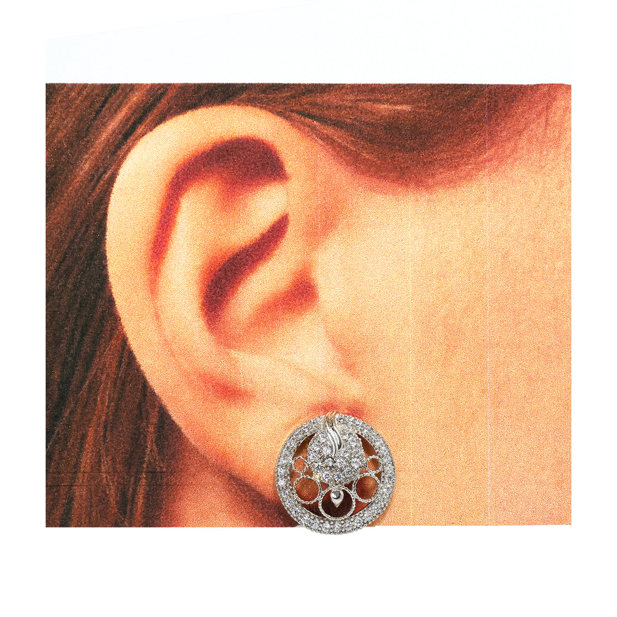 Close-up of an ear wearing a decorative earring with intricate design.