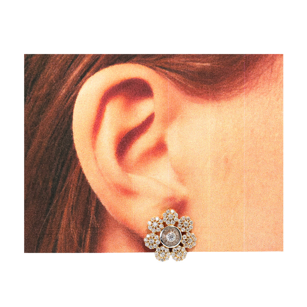 Close-up of an ear wearing a decorative floral earring.