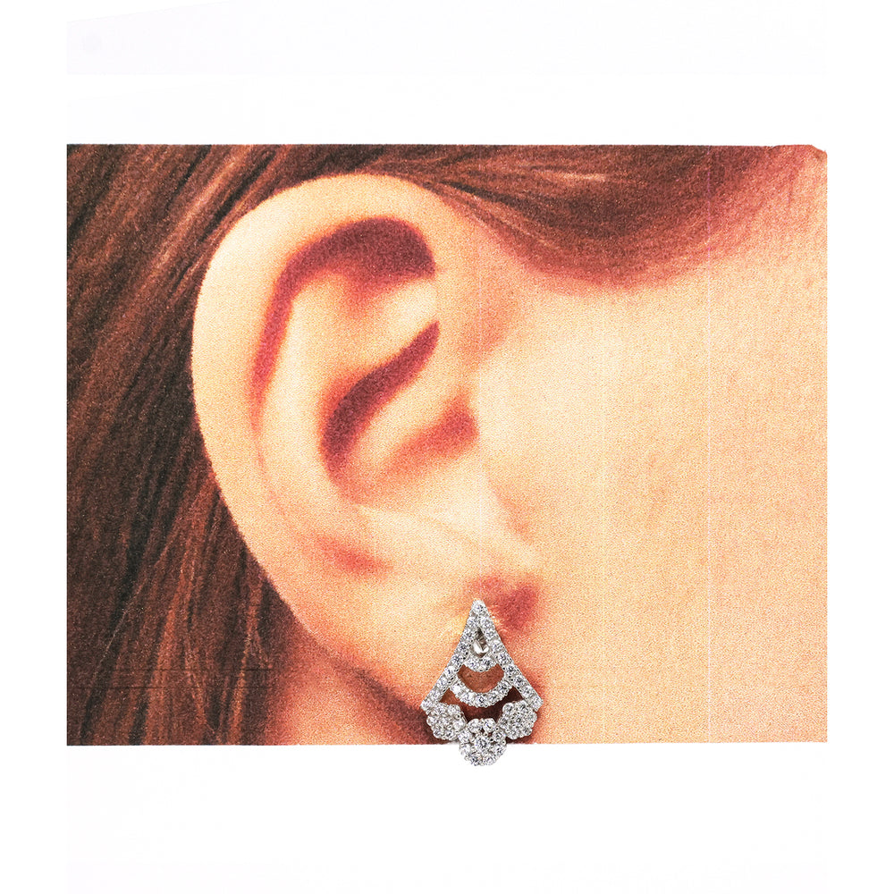 Close-up of an ear wearing a diamond earring with a white background
