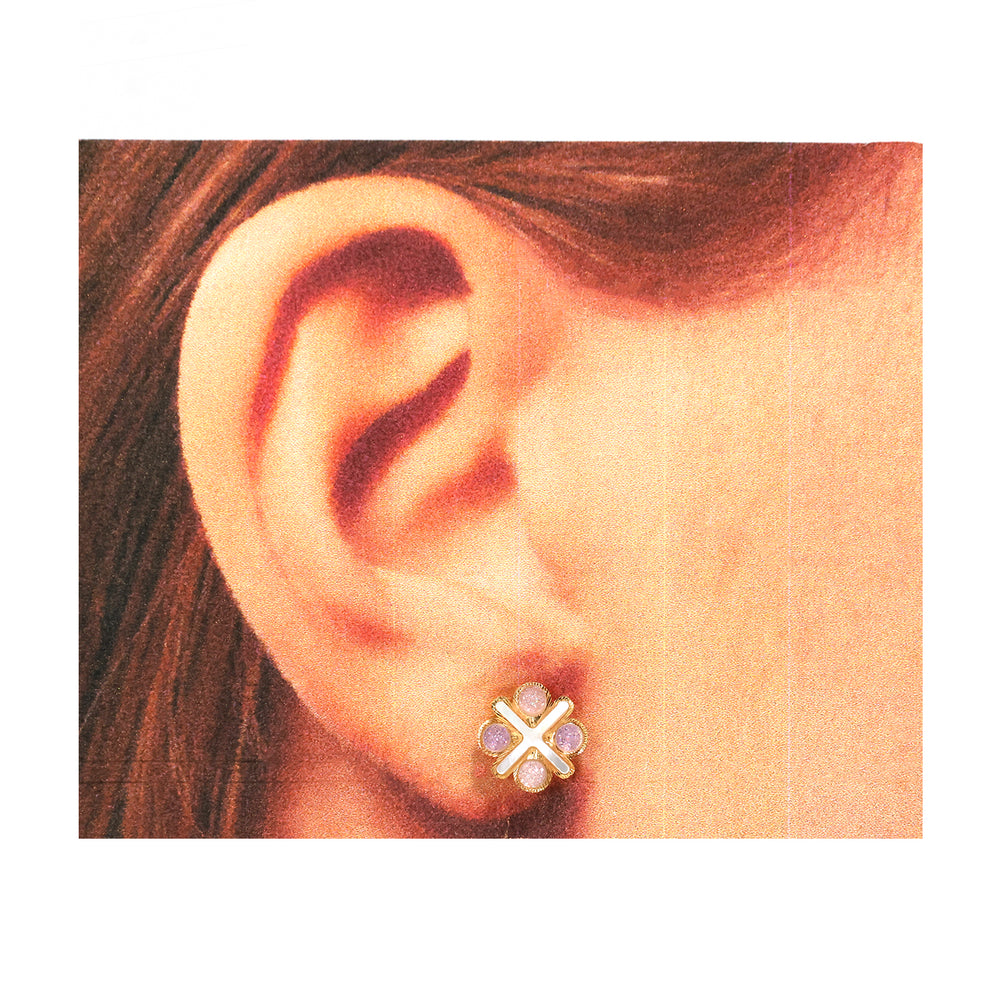 Close-up of an ear wearing a floral earring with gold and purple details.