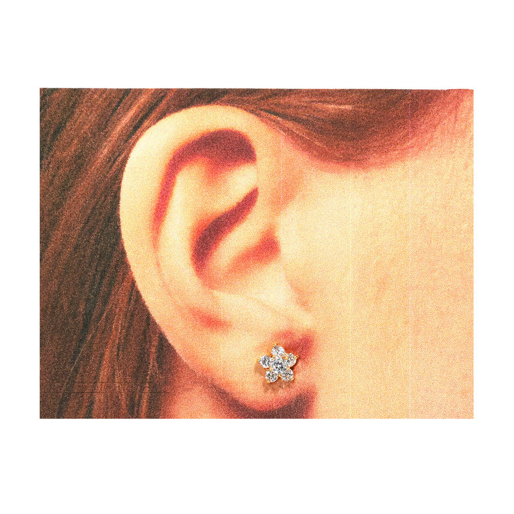Close-up of an ear wearing a diamond flower earring.