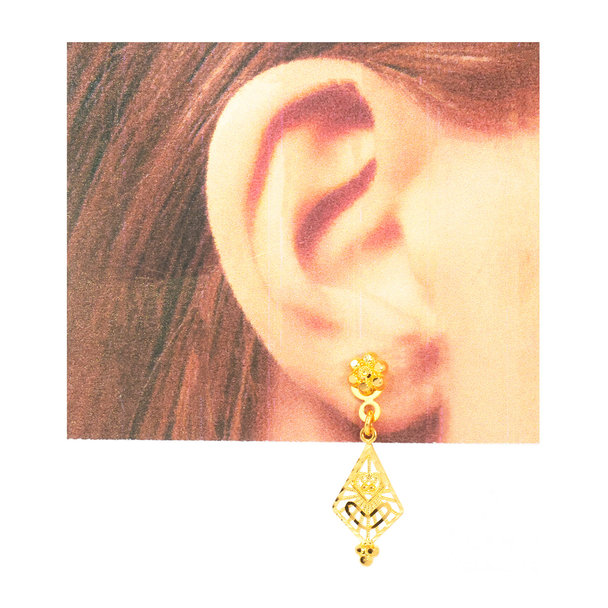 A gold-toned geometric dangle earring with a floral stud, shown worn on a person's ear against a white background.