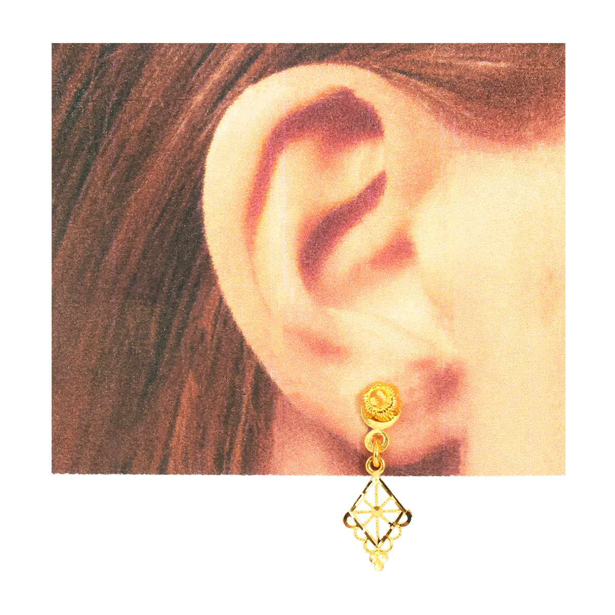 A close-up of a person's ear wearing a small gold hoop earring with a dangling geometric gold charm, shown against a white background.