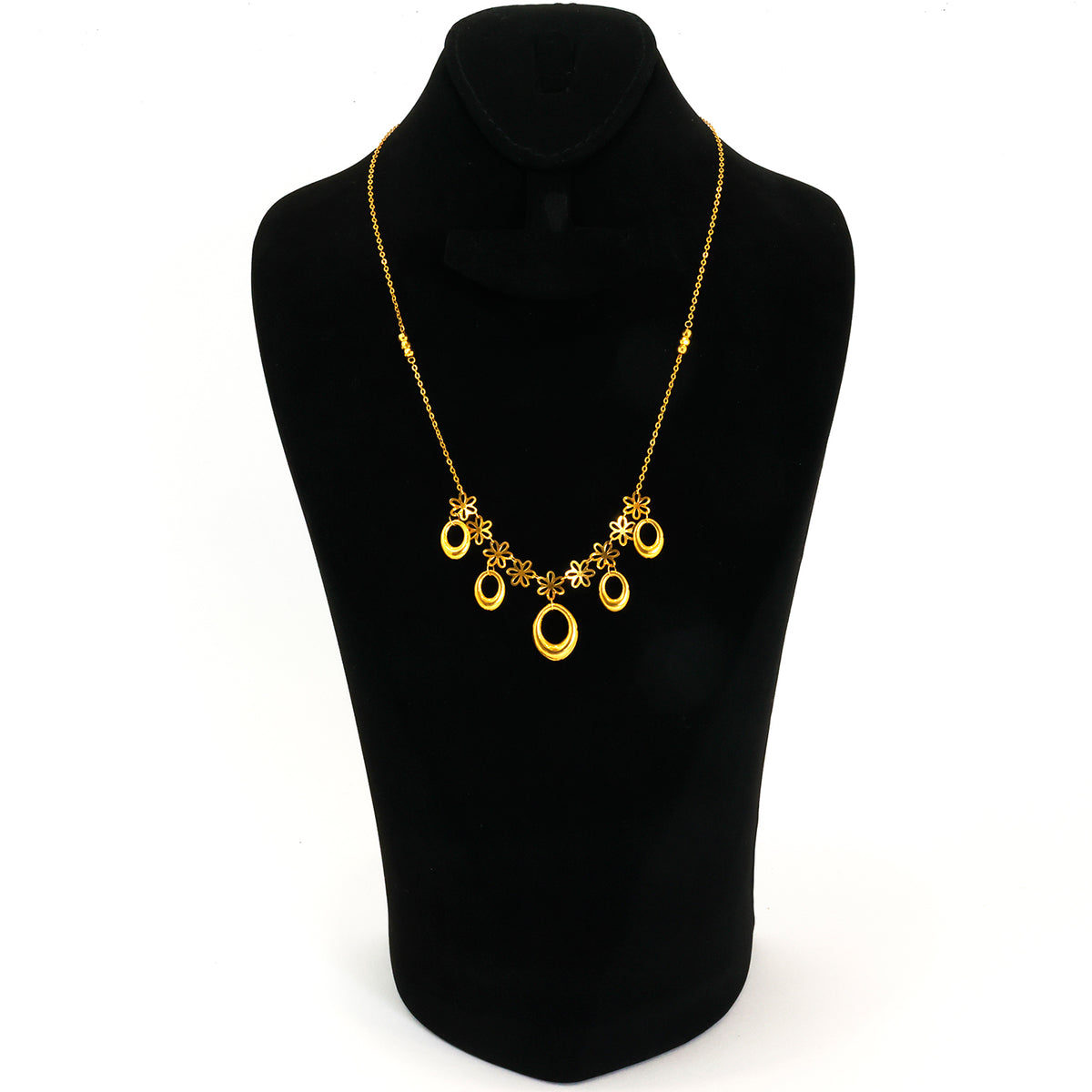 Gold necklace on a black mannequin bust against a white background
