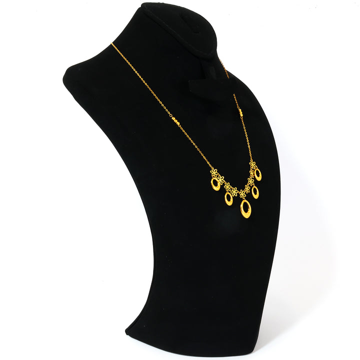 Gold necklace with a blue pendant on a black mannequin bust.