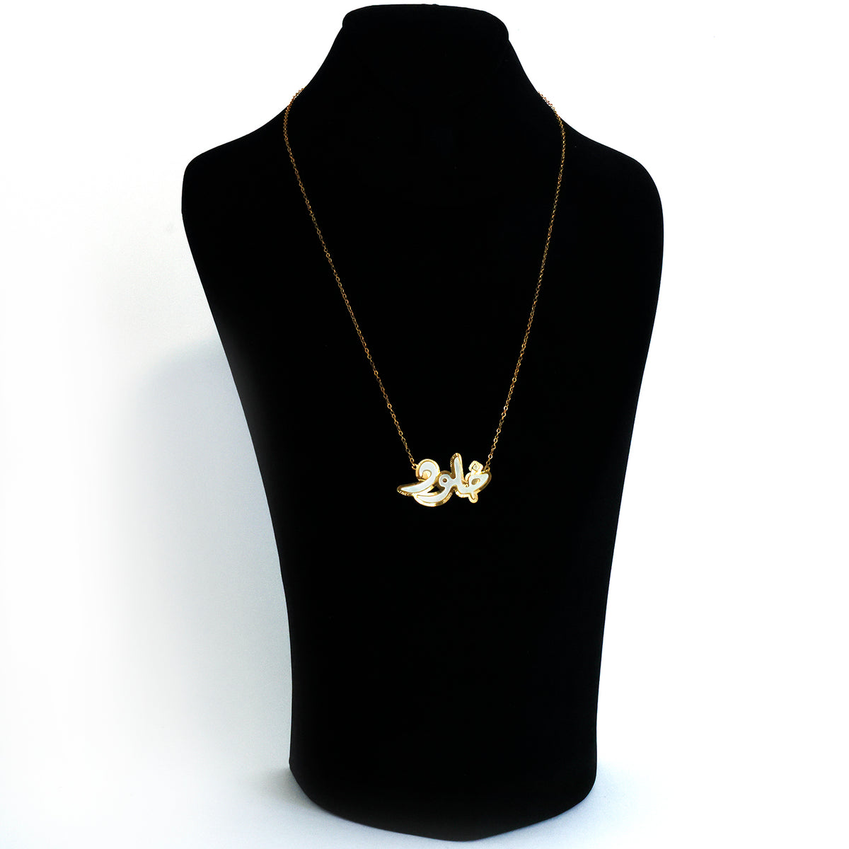 Gold necklace on a black mannequin bust against a white background