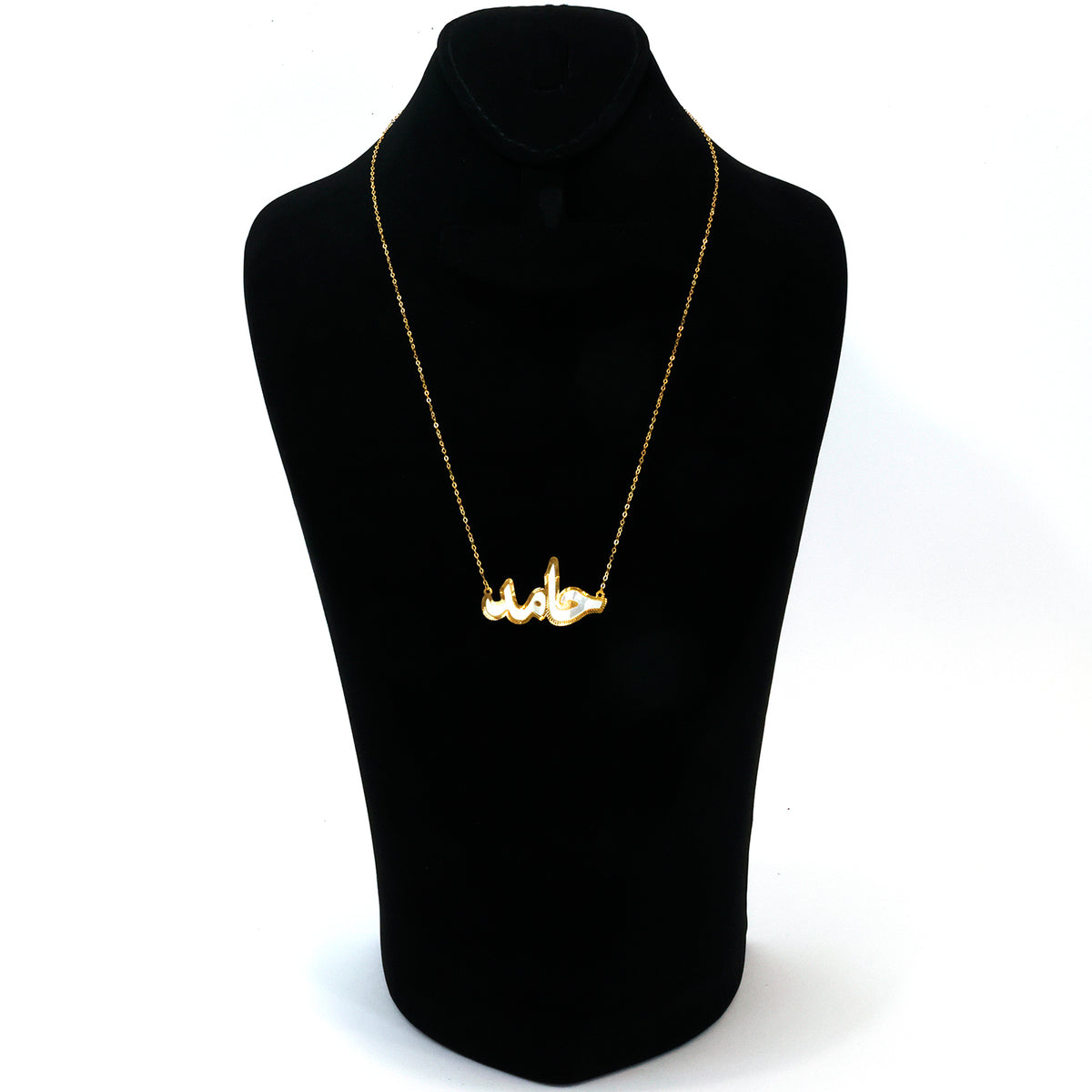 Gold necklace on a black mannequin with a white background