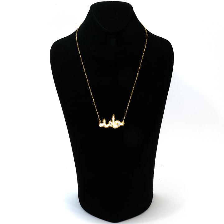 Gold necklace on a black mannequin with a white background