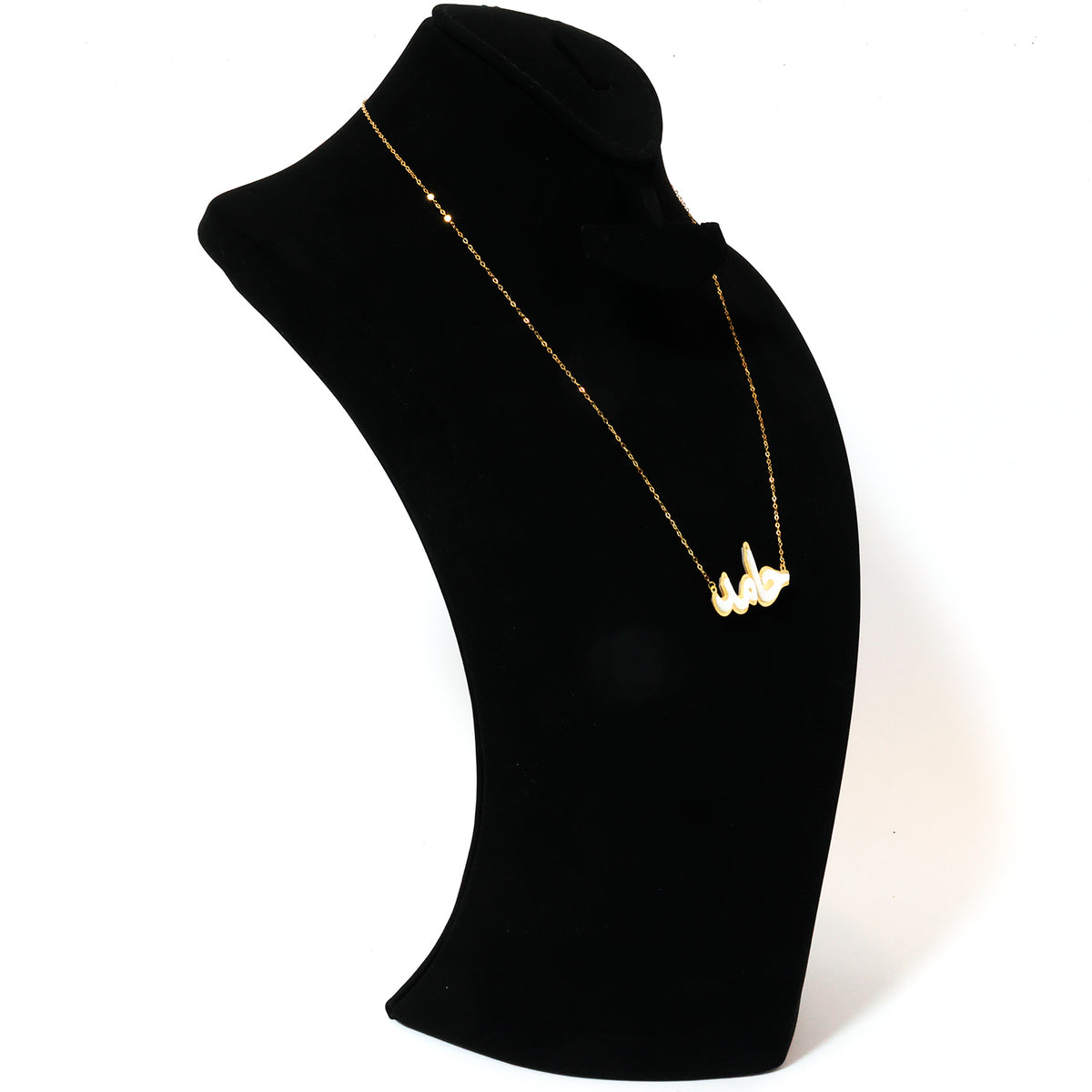 Gold necklace on a black mannequin bust against a white background