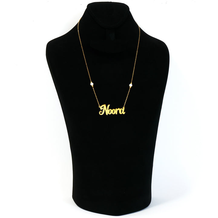 Gold necklace with 'Noori' pendant on a black mannequin bust.