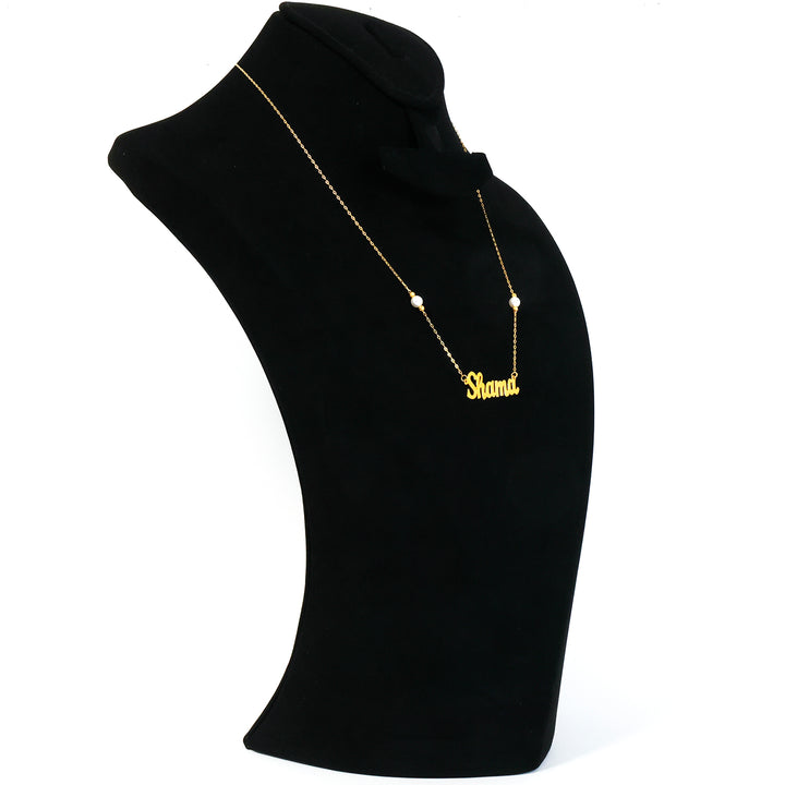 Black mannequin bust with a gold necklace on a white background
