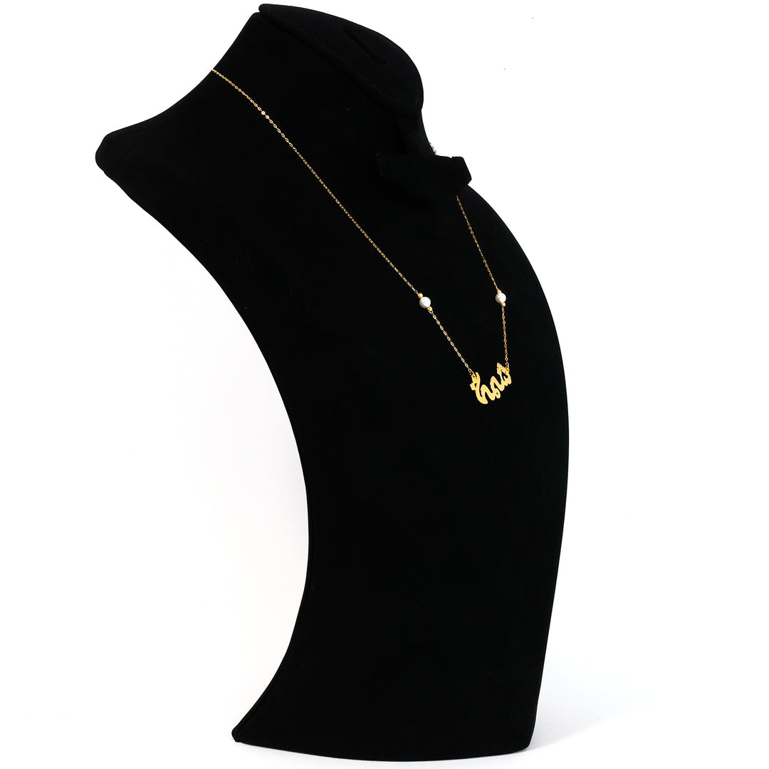 Gold necklace with a pendant on a black mannequin bust against a white background