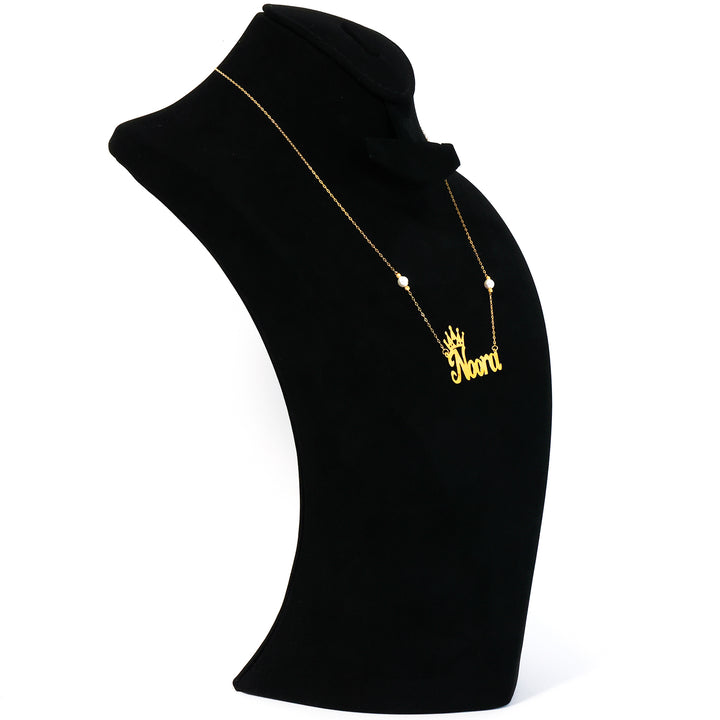 Gold necklace with a pendant on a black mannequin bust against a white background