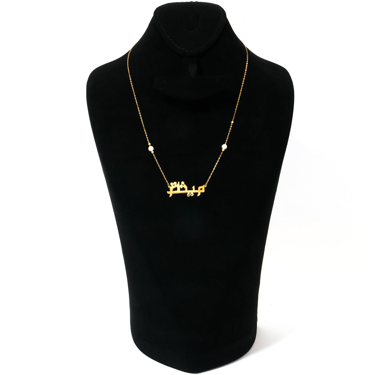 Gold necklace with Arabic script on a black mannequin bust against a white background