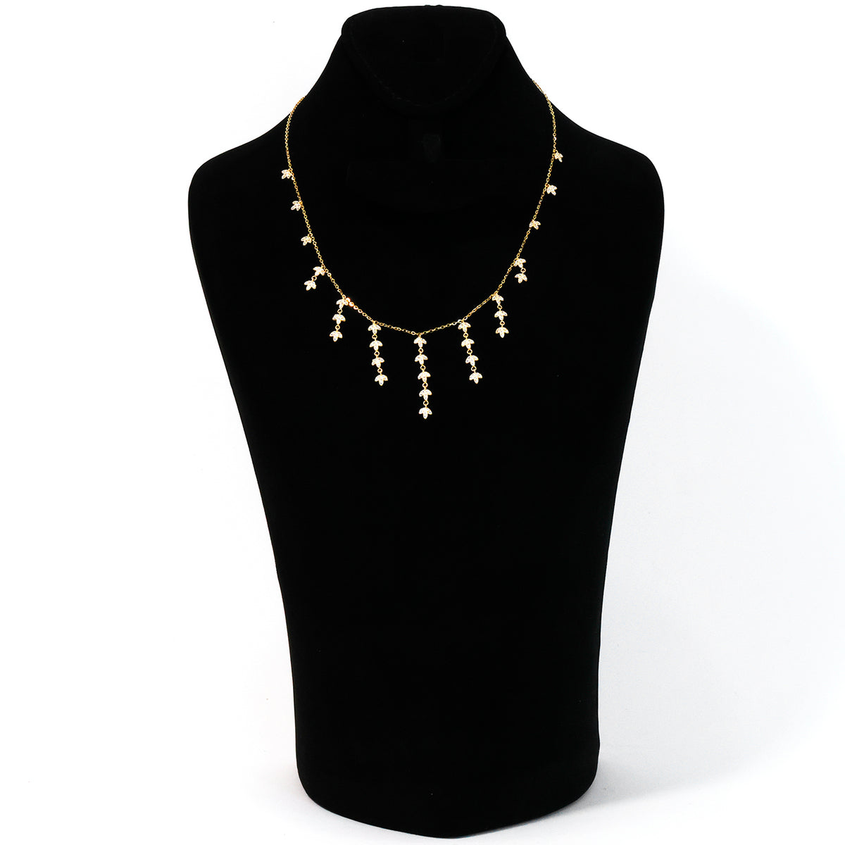 Gold necklace on a black mannequin bust against a white background
