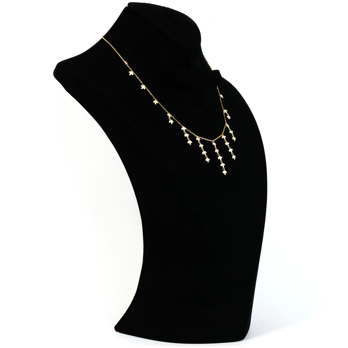 Pearl necklace on a black mannequin bust against a white background