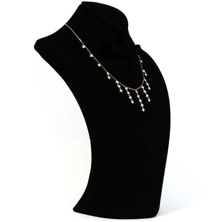 Pearl necklace on a black mannequin bust against a white background