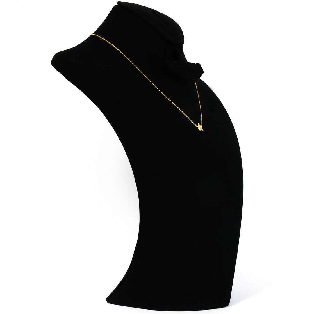 Black turtleneck sweater with a gold necklace on a mannequin against a white background