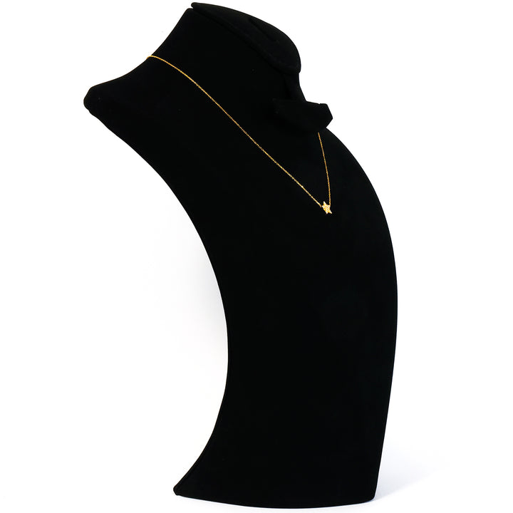 Black turtleneck sweater with a gold necklace on a mannequin against a white background