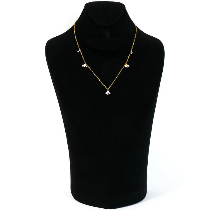 Gold necklace on a black mannequin bust against a white background
