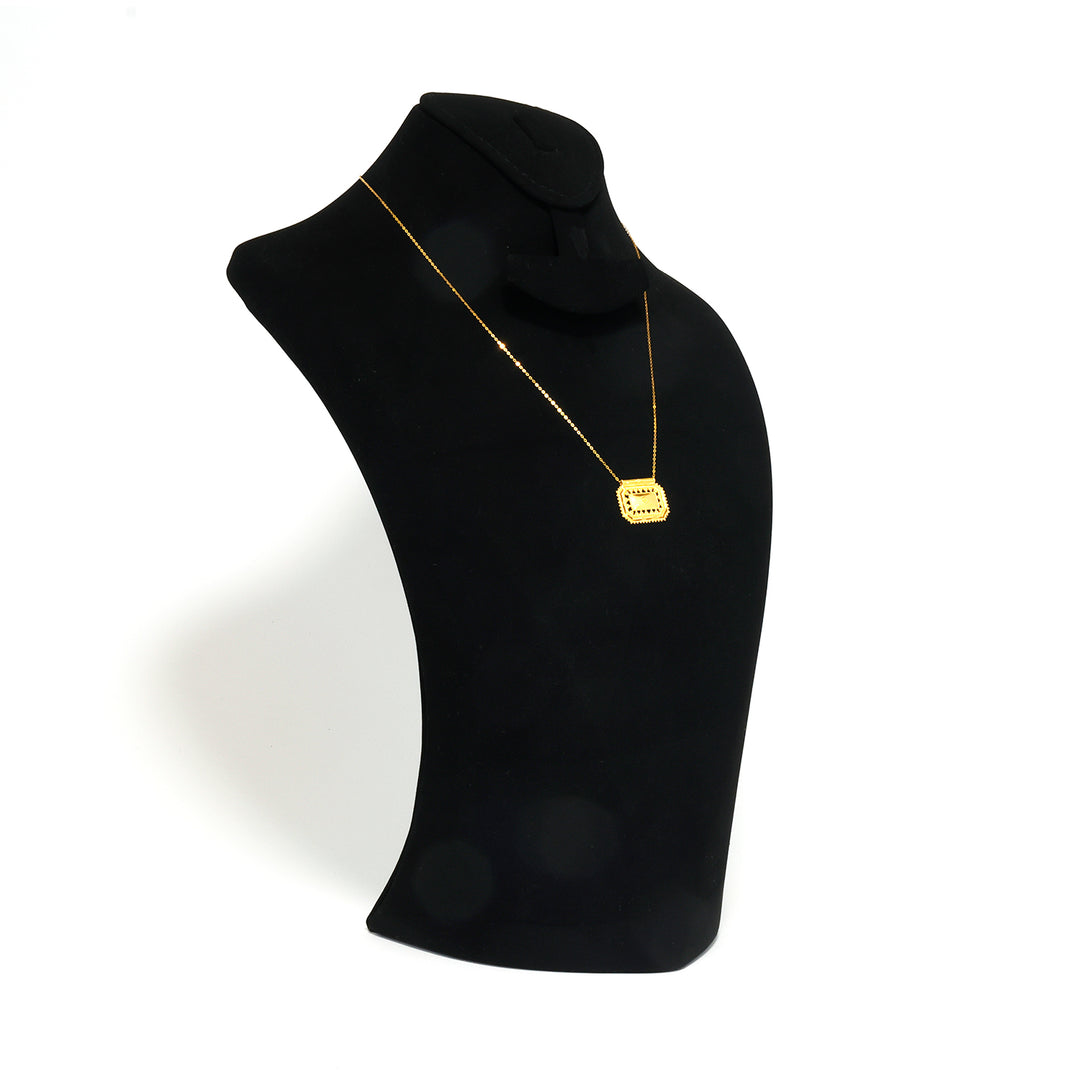 Black turtleneck sweater with a gold necklace on a mannequin against a white background