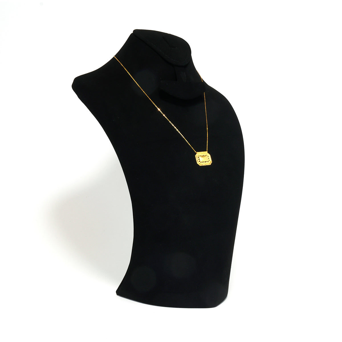 Black turtleneck sweater with a gold necklace on a mannequin against a white background