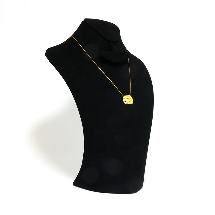 Black turtleneck sweater with a gold necklace on a mannequin against a white background