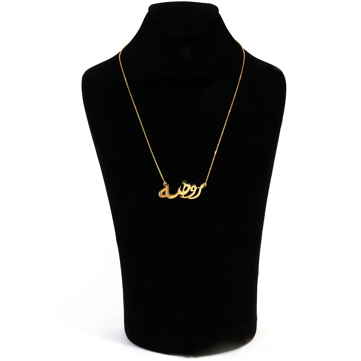 Gold necklace on a black mannequin bust with a white background