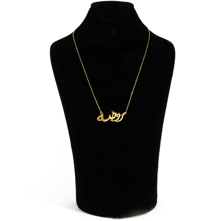 Gold necklace on a black mannequin bust with a white background