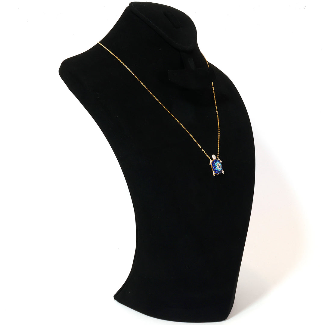 Gold necklace with a blue pendant on a black mannequin bust.
