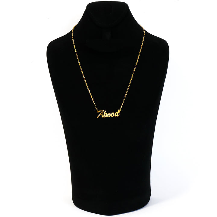 Gold necklace with 'Abood' pendant on a black mannequin bust.