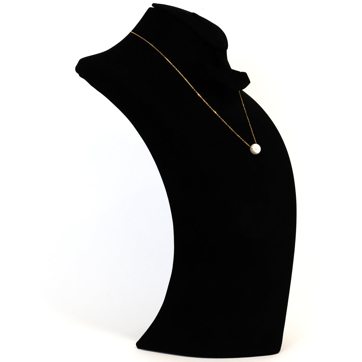Black mannequin bust with a gold necklace and pearl pendant on a white background