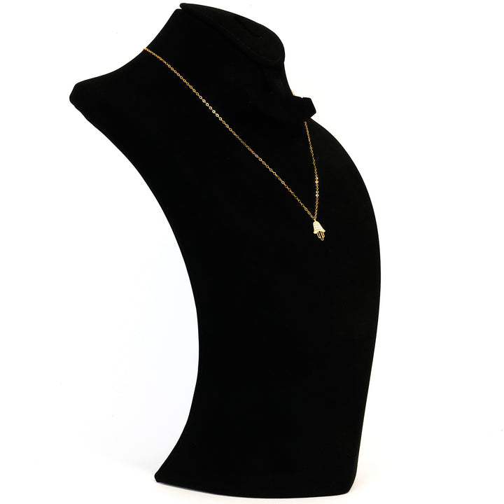 Black turtleneck garment with a gold necklace on a white background
