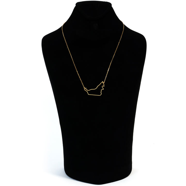 Gold necklace on a black mannequin bust against a white background