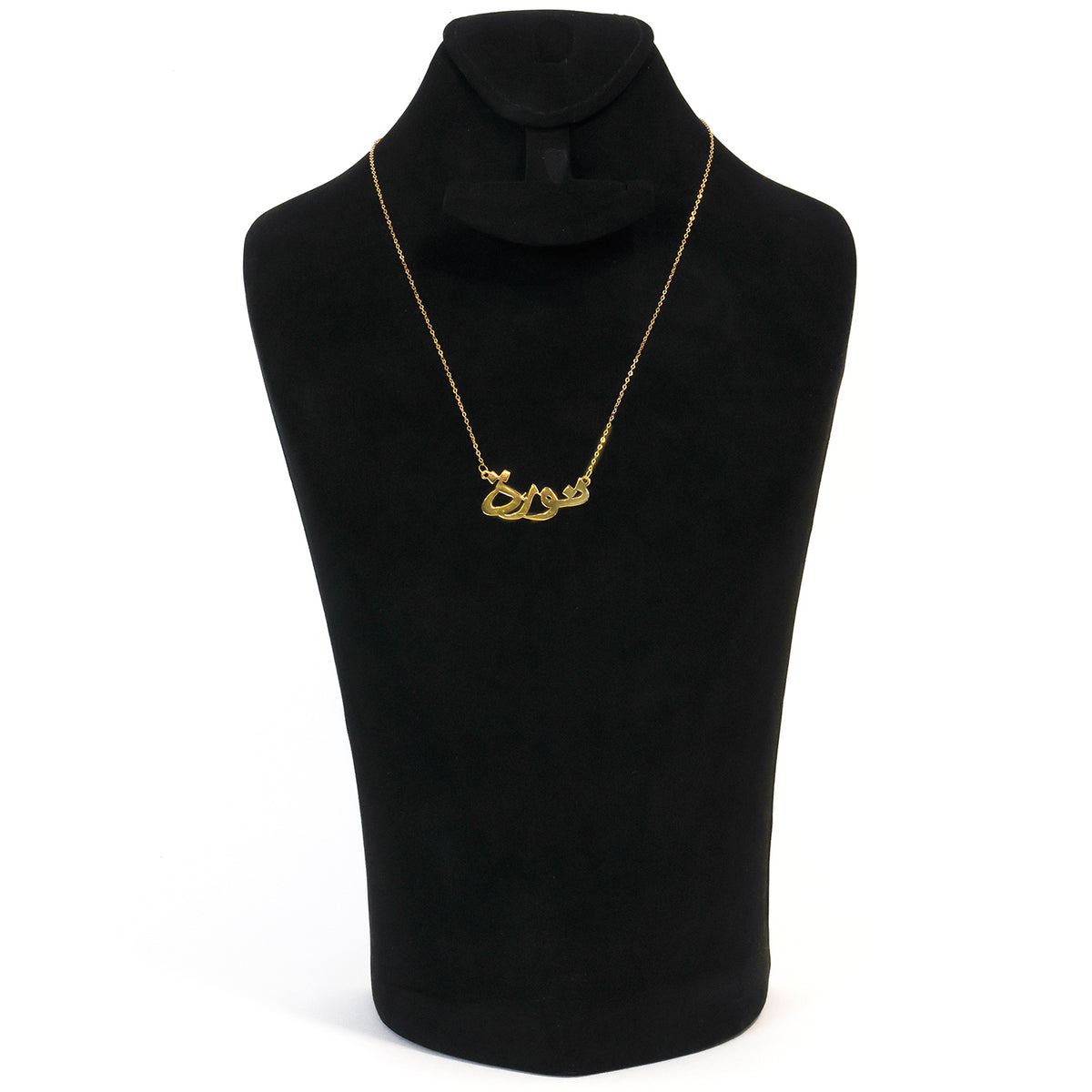Gold necklace on a black mannequin bust against a white background