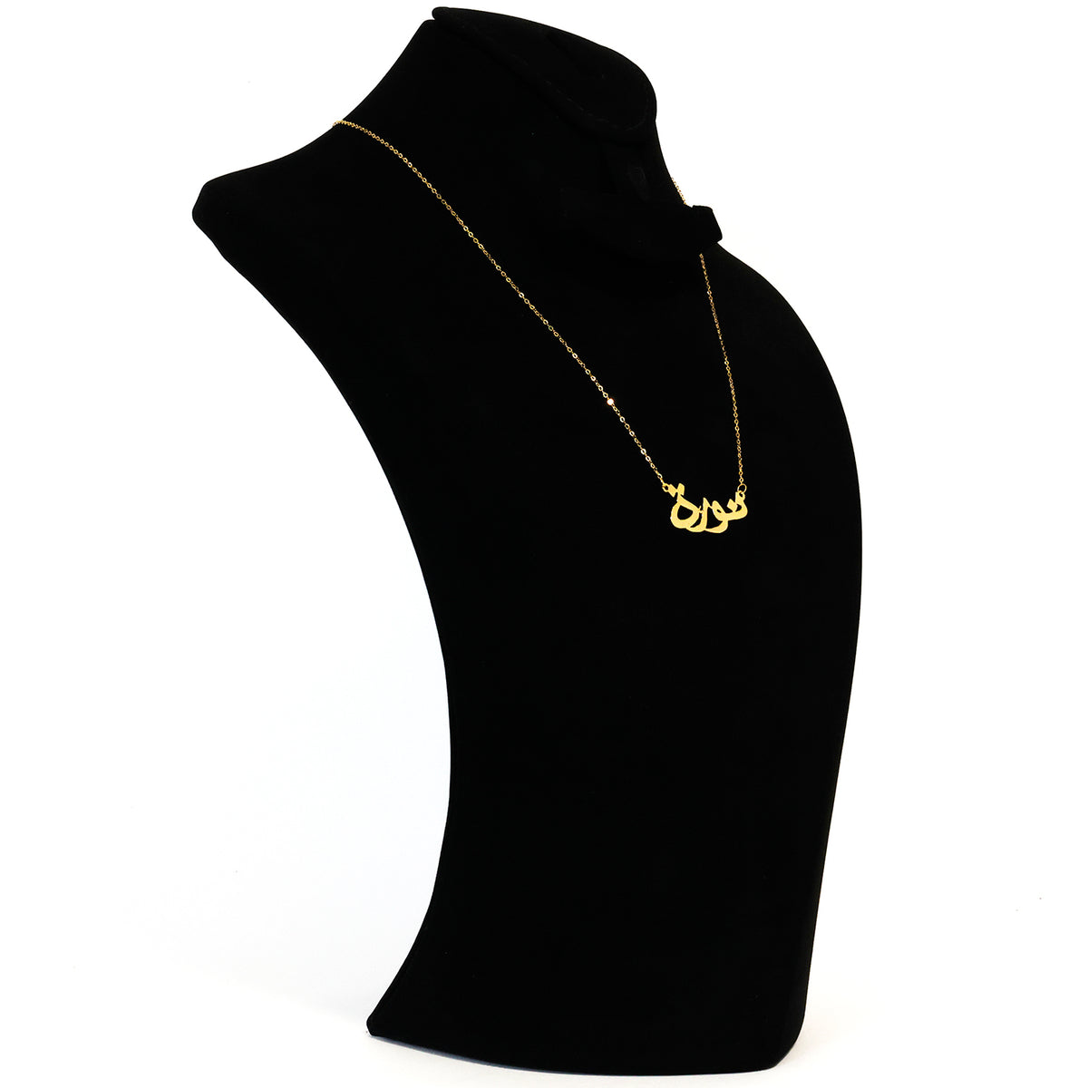 Gold necklace on a black mannequin bust against a white background