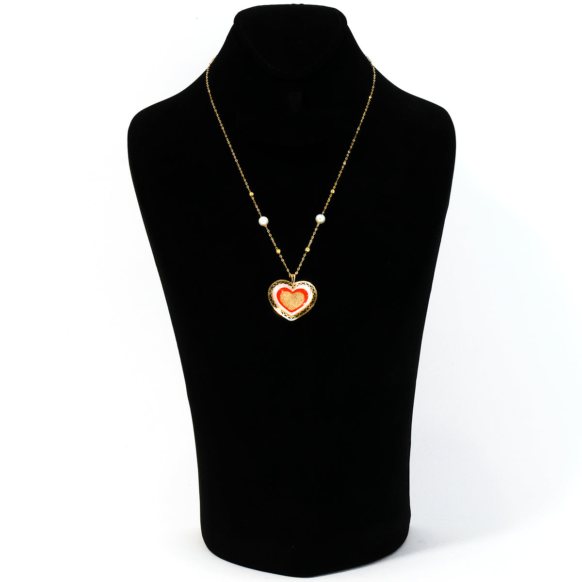 Necklace with a heart-shaped pendant on a black mannequin bust.