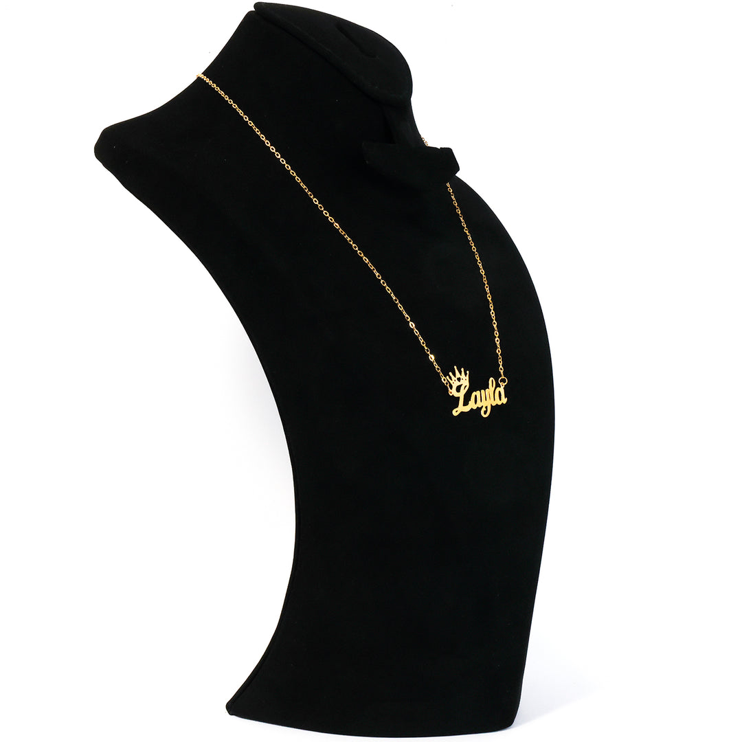 Black turtleneck with gold necklace and 'ANATOL' pendant on a white background
