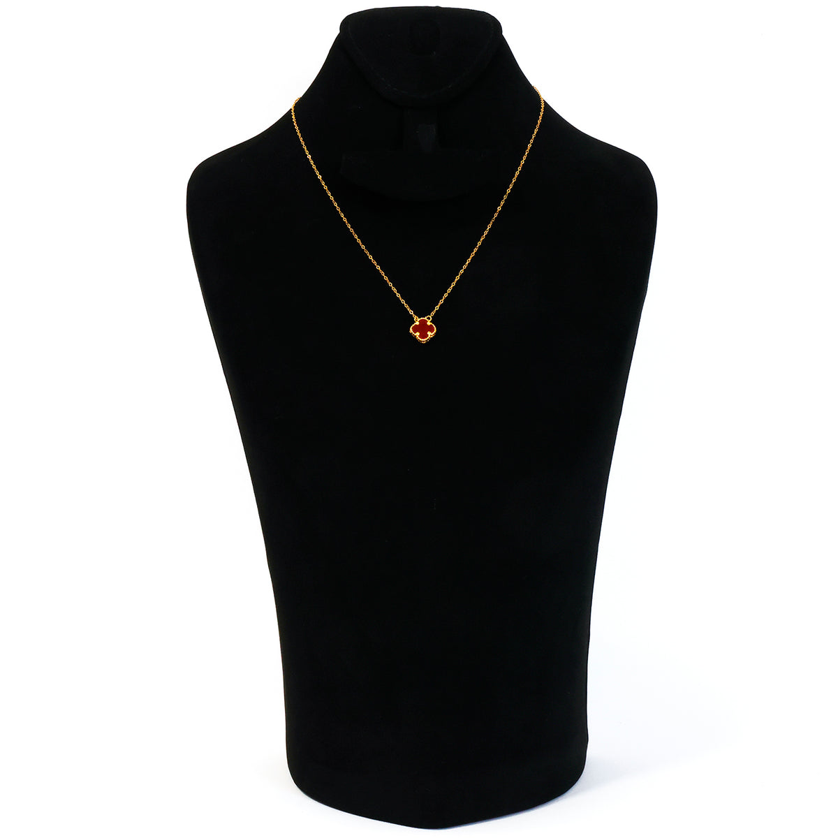 Gold necklace with a red pendant on a black mannequin bust against a white background