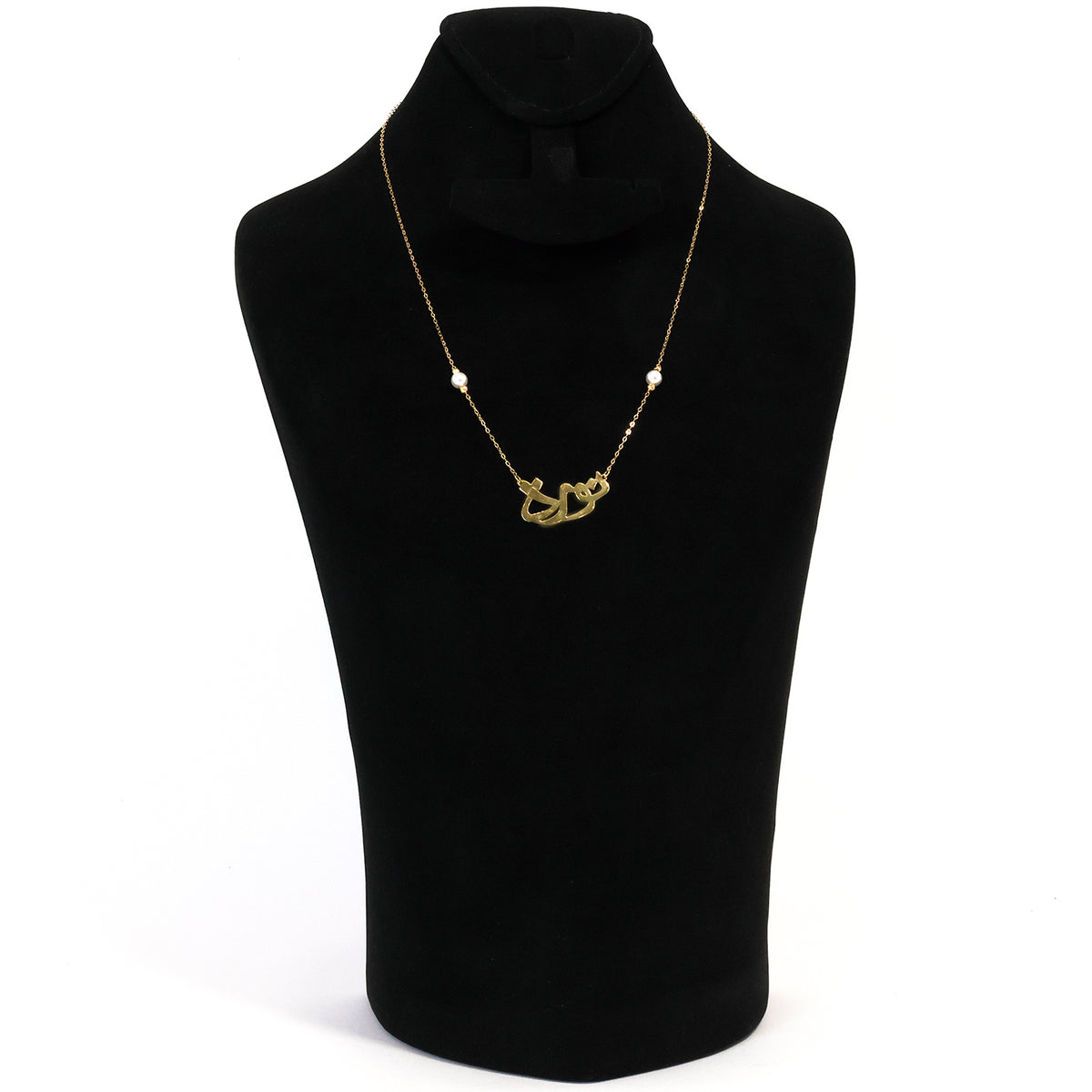 Gold necklace on a black mannequin bust with a white background