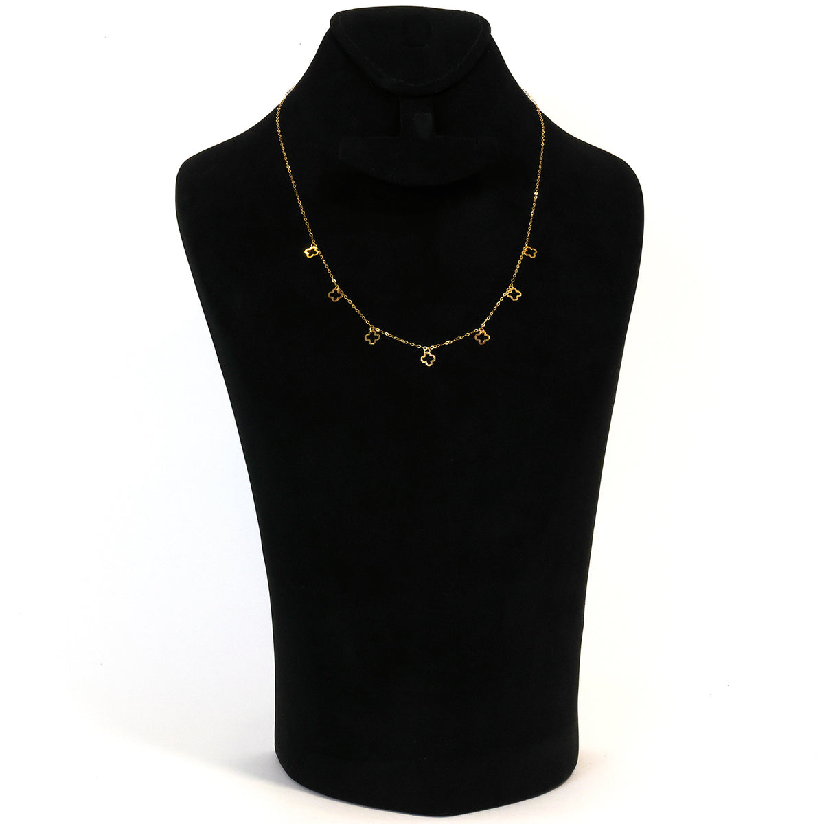 Gold necklace on a black mannequin bust against a white background