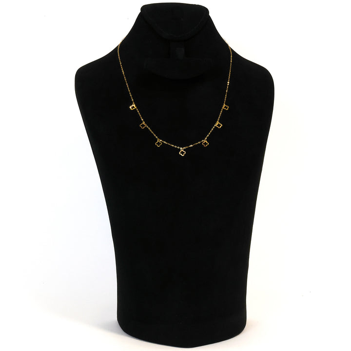 Gold necklace on a black mannequin bust against a white background